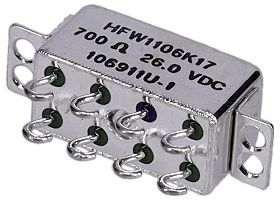 Eine silberne elektronische Komponente mit Seriennummer 'HFW1106K17' und Spezifikationen '700 Ω 26,0 VDC', versehen mit mehreren Metallpins.