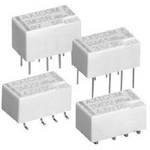 Vier weiße elektronische Relaisbauteile mit mehreren Pins für elektrische Verbindungen.