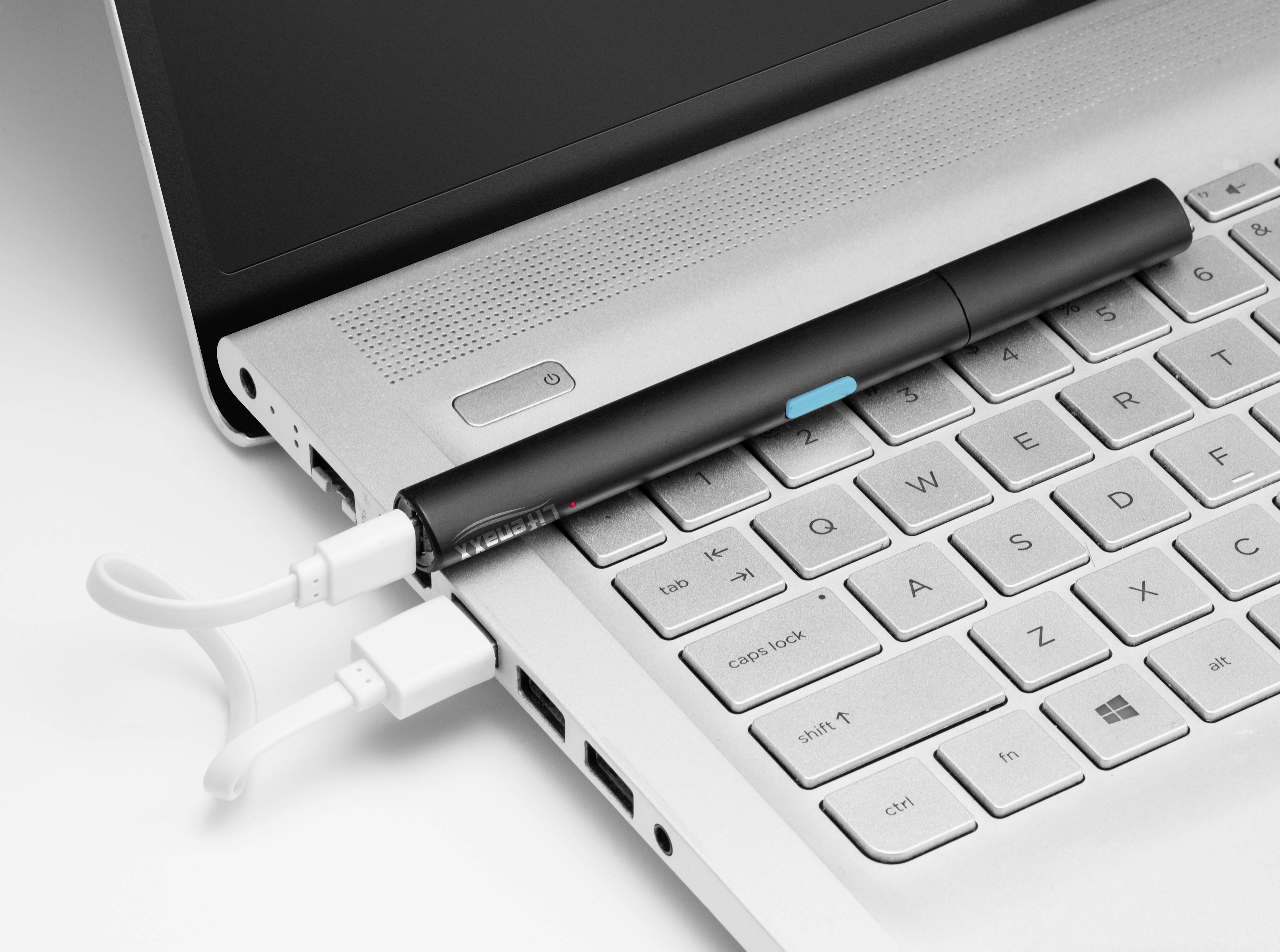 Ein schwarzer Stift liegt auf einer Laptoptastatur. Ein USB-Kabel ist neben dem Stift angeschlossen, was auf technologische Funktionalität hinweist.