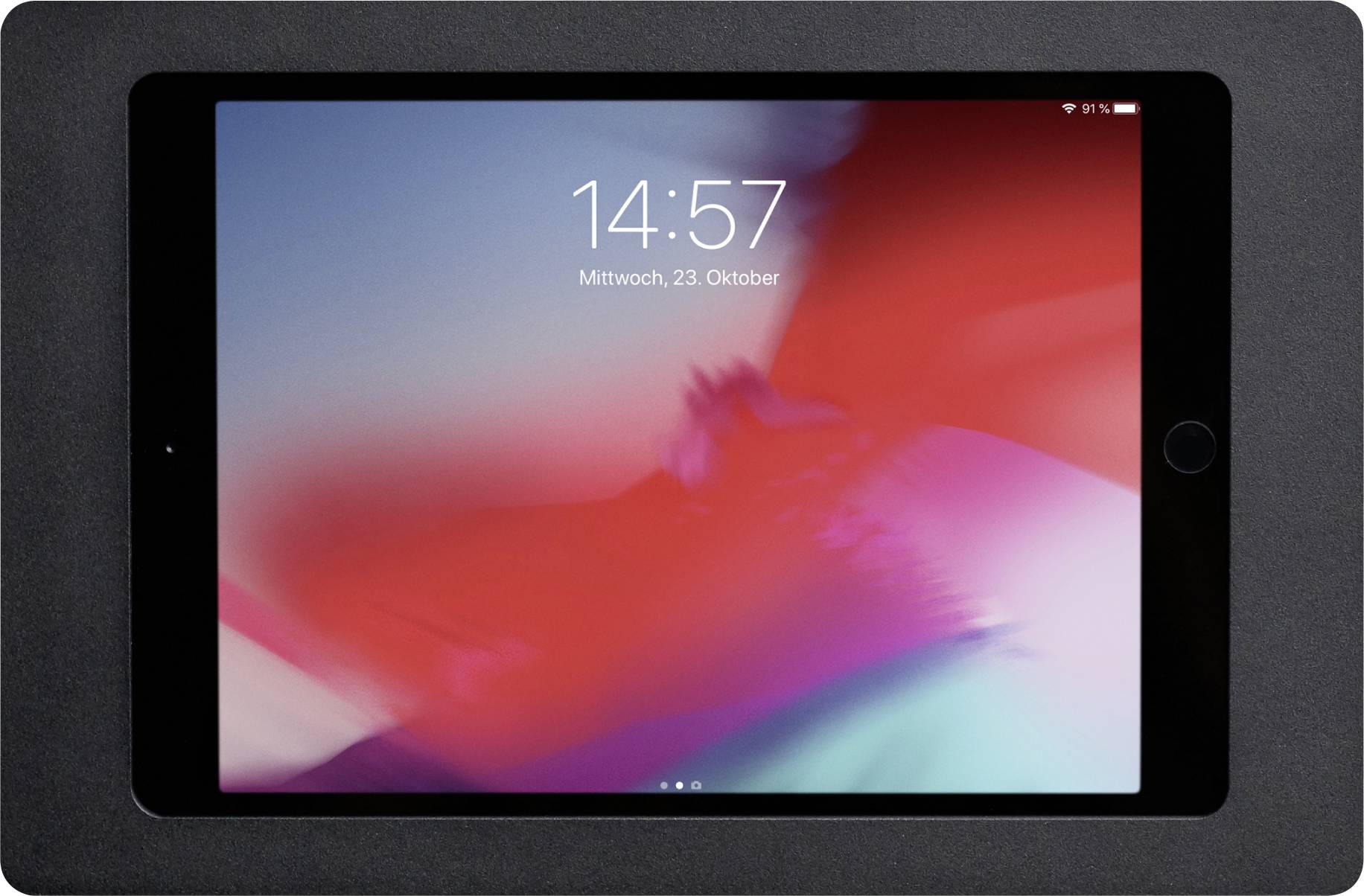 Ein Tablet mit einem farbenfrohen Hintergrundbild zeigt die Uhrzeit '14:57' und das Datum 'Mittwoch, 23. Oktober' auf dem Bildschirm an.