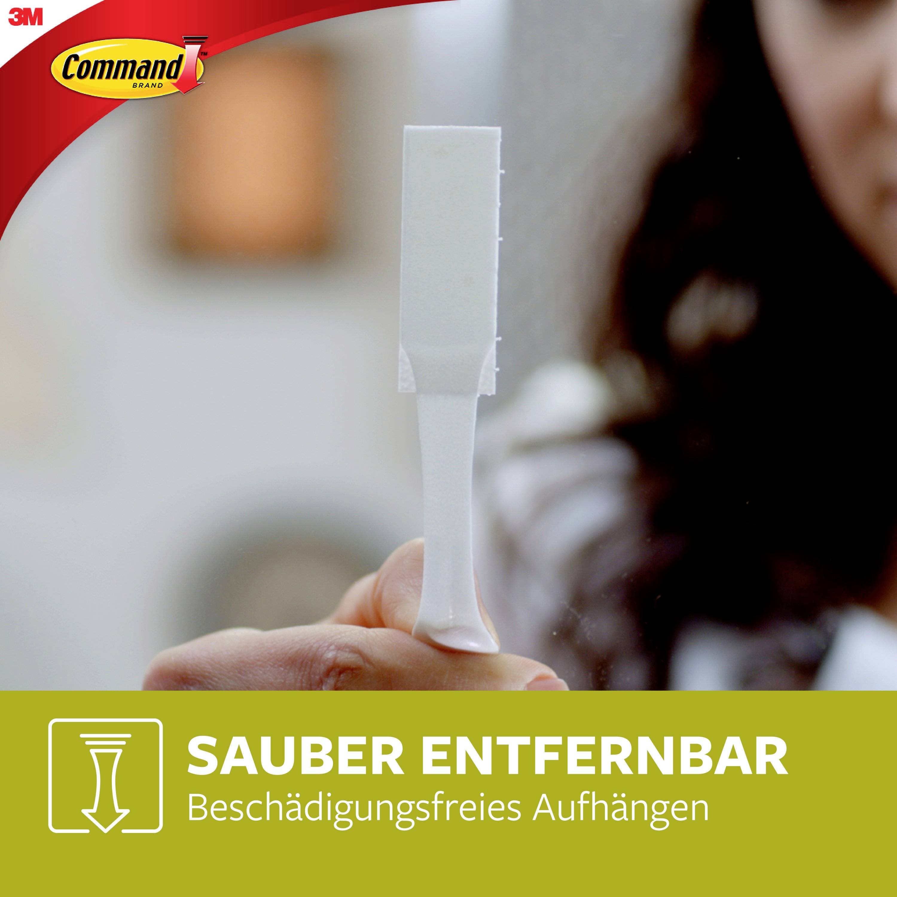 Frau hält einen weißen Haken in der Hand. Aufschrift unten: 'Sauber entfernbar - Beschädigungsfreies Aufhängen'. 3M-Logo oben links.