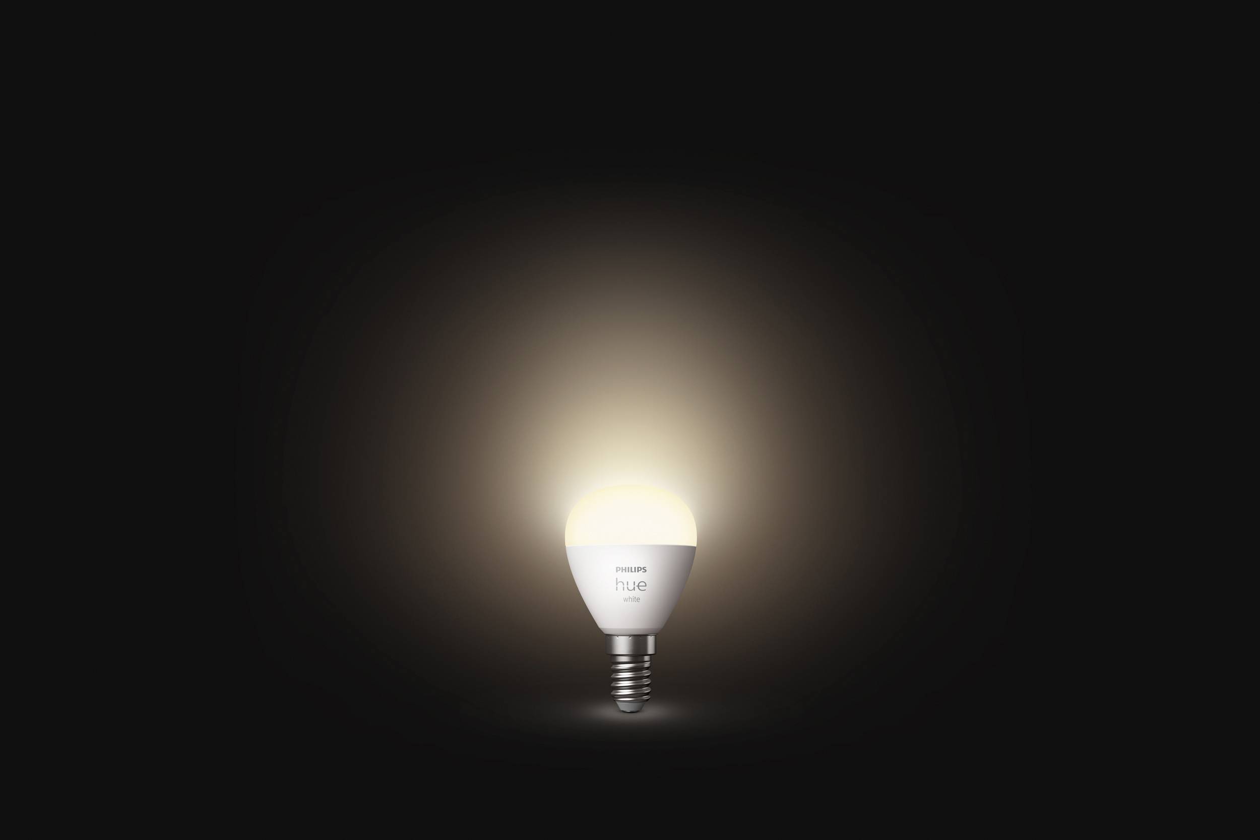 Eine einzelne, leuchtende Glühbirne auf schwarzem Hintergrund. Sie erzeugt einen warmen Lichtschein und steht für Beleuchtung oder Ideen.