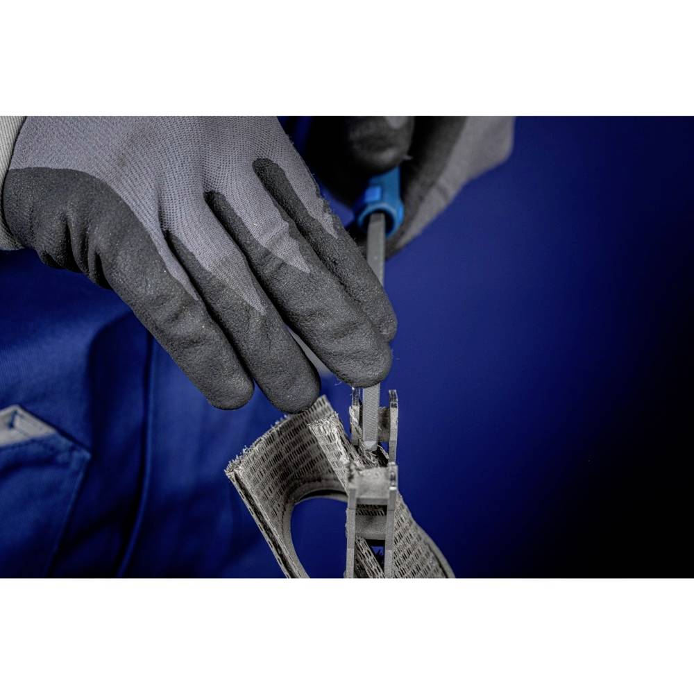Handschuhtragende Person schneidet Metallgeflecht mit einer Zange gegen einen blauen Hintergrund. Fokus auf den Schneidevorgang.