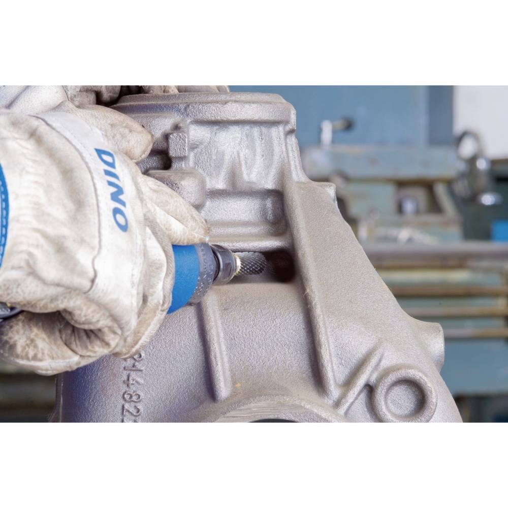 Eine Person trägt Arbeitshandschuhe und schleift mit einem blauen Werkzeug eine Metallfläche. Industriewerkzeug im Einsatz.