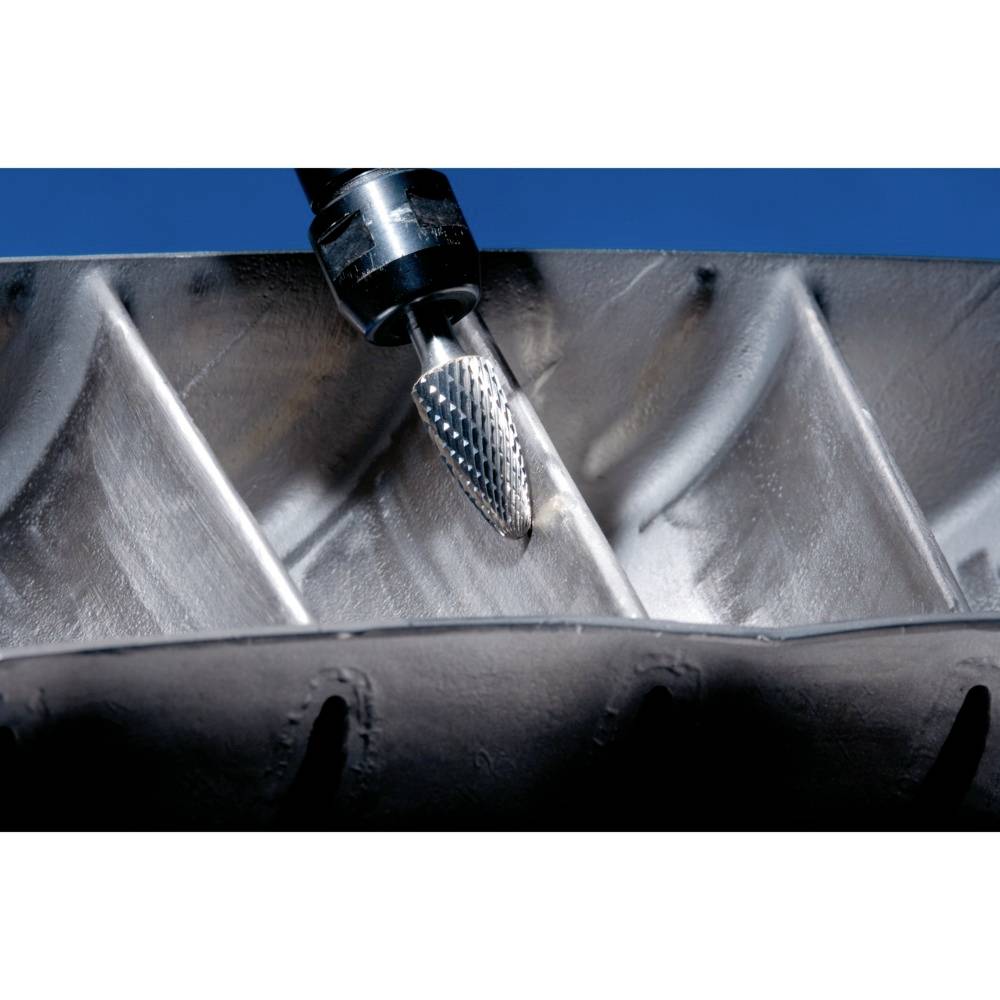 Ein Metallfräser bearbeitet die Innenfläche eines großen Maschinenbauteils. Der Fräskopf erzeugt dabei sichtbare glatte Spuren.