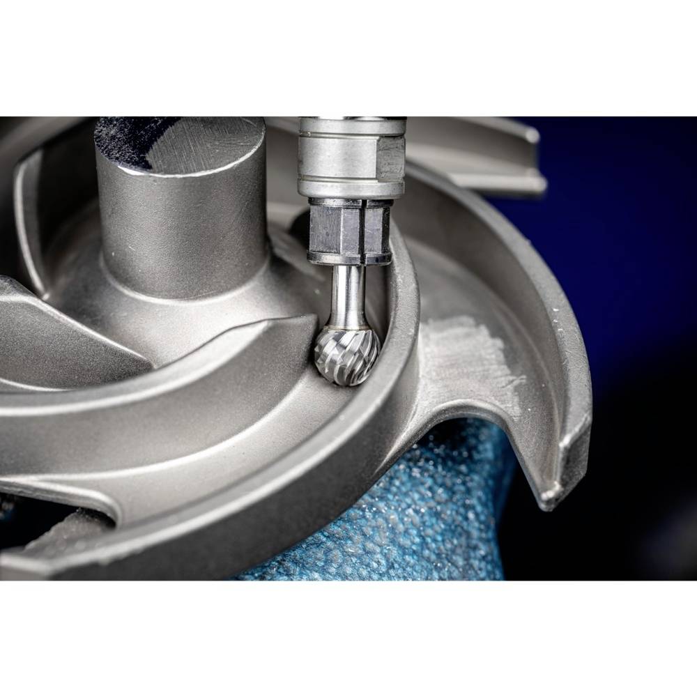 Nahaufnahme einer CNC-Fräsmaschine, die eine Turbinenkomponente bearbeitet. Der Fräser formt präzise die Metalloberfläche der Schaufeln.