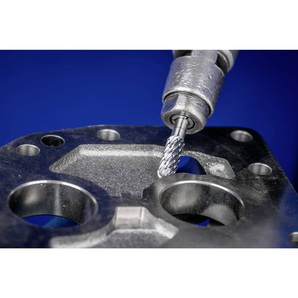 Fräsmaschine mit Metallbohrer bearbeitet ein Metallblech. Der Bohrer dreht sich, erzeugt Löcher und glattet die Oberfläche.