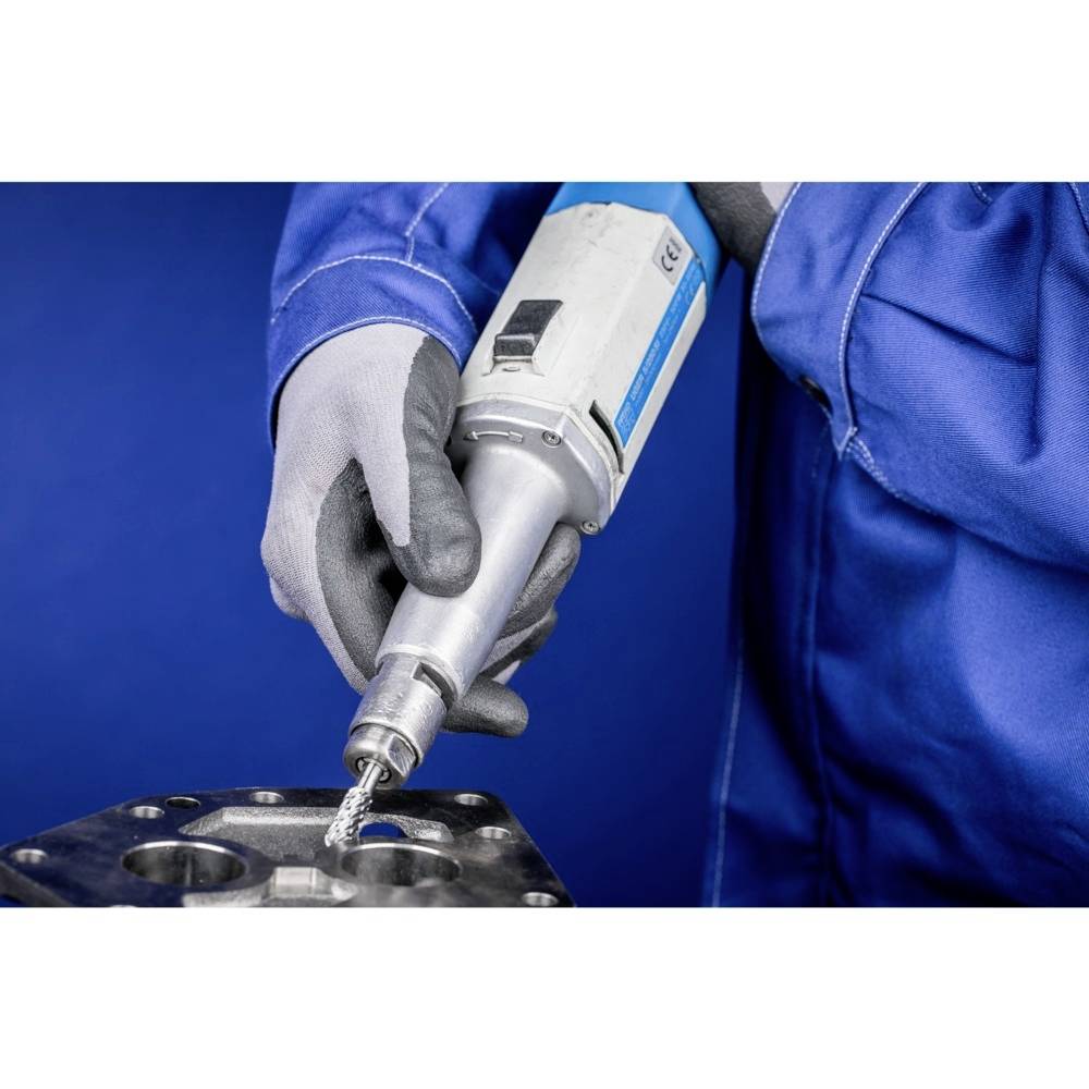 Eine Person in blauer Arbeitskleidung verwendet ein Elektrowerkzeug, um Metall zu bearbeiten. Machine und Hände sind im Fokus.