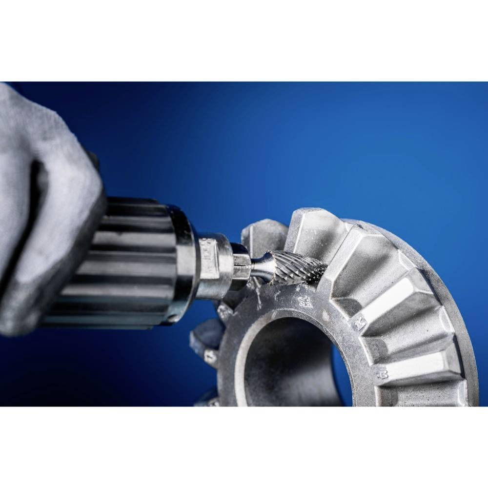 Ein Metallgetriebe wird mit einem rotierenden Werkzeug bearbeitet. Eine Person trägt dabei einen grauen Handschuh. Der Hintergrund ist blau.