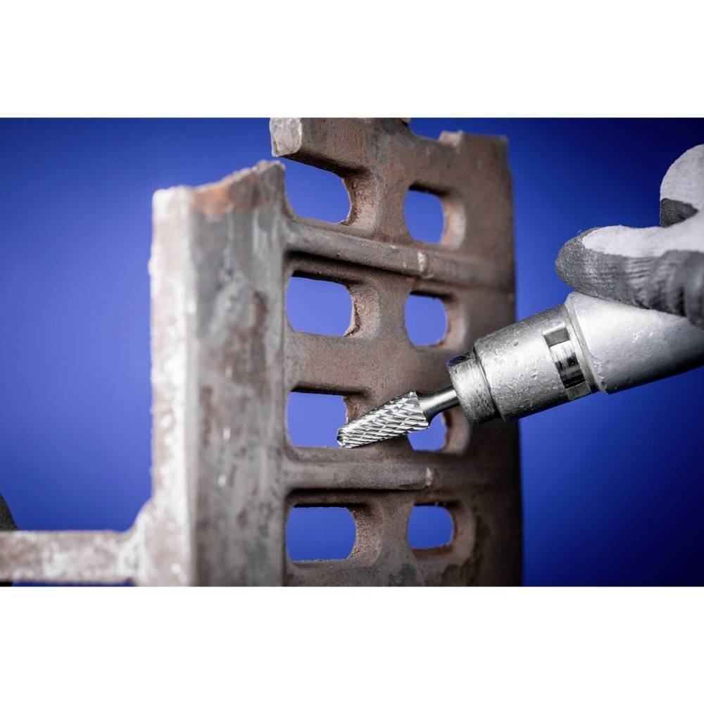 Eine Hand, die ein Werkzeug mit einem rotierenden Fräser hält, bearbeitet ein Metallteil mit rechteckigen Öffnungen.