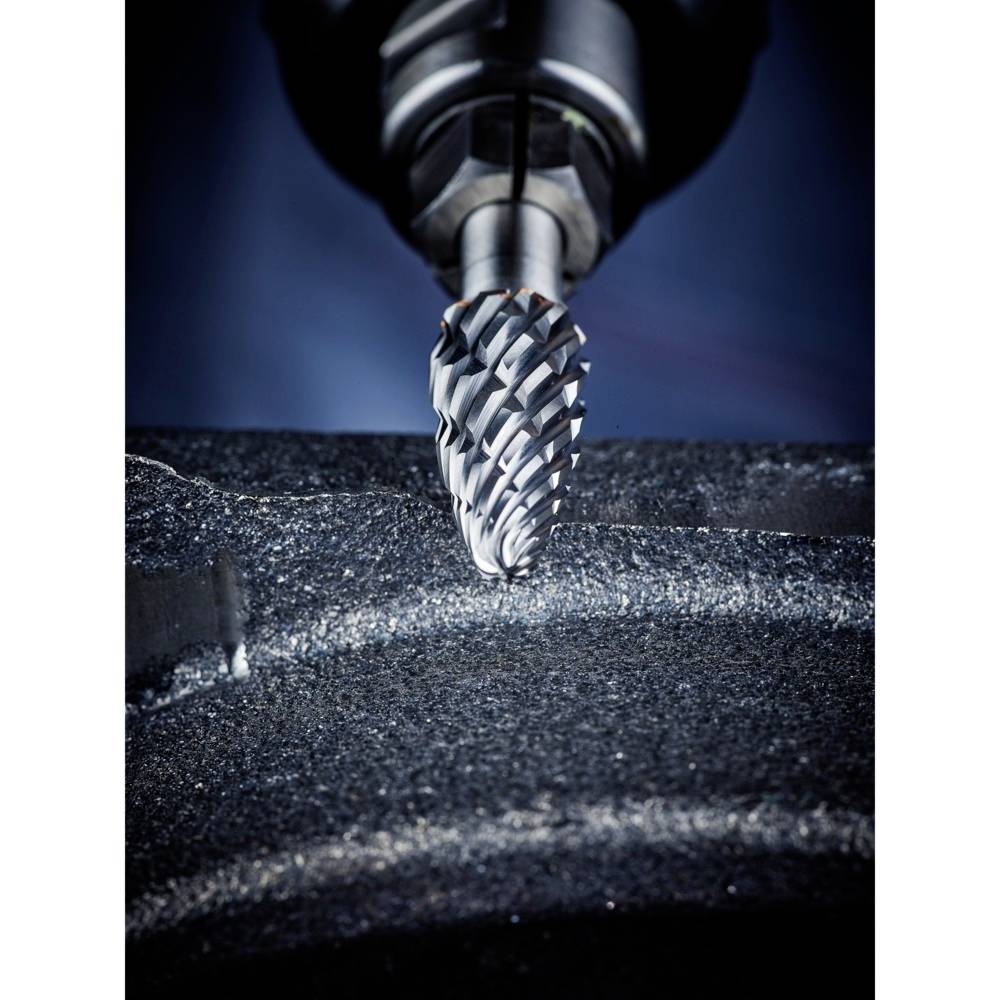 Ein Bohrkopf bearbeitet eine Metallfläche, wobei Späne erzeugt werden. Die Szene zeigt präzise Metallbearbeitung in industrieller Umgebung.