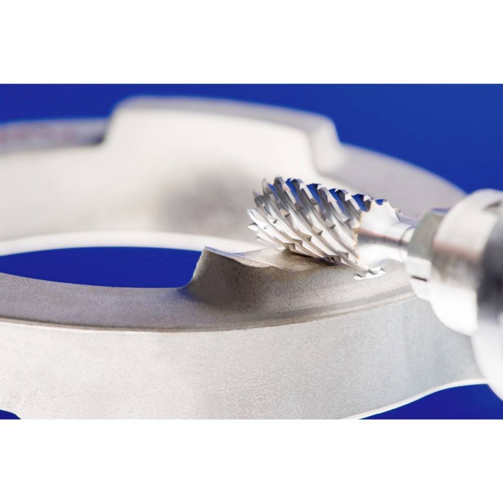 Ein Metallfräser bearbeitet die Kante eines Metallrings. Der Fokus liegt auf dem Fräskopf und dem präzisen Arbeitsvorgang.