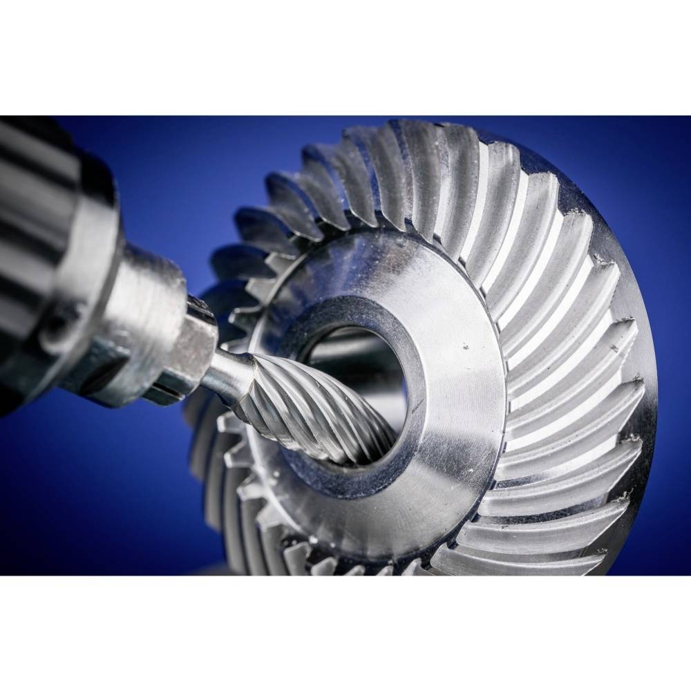 Nahaufnahme eines Metallfräsers und eines verzahnten Zahnrads auf blauem Hintergrund, zeigt präzise Bearbeitungstechnologie.