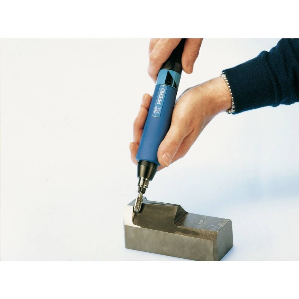 Eine Person hält ein blaues Werkzeug und bearbeitet die Kante eines Metallblocks. Das Werkzeug dreht sich und glättet die Oberfläche.