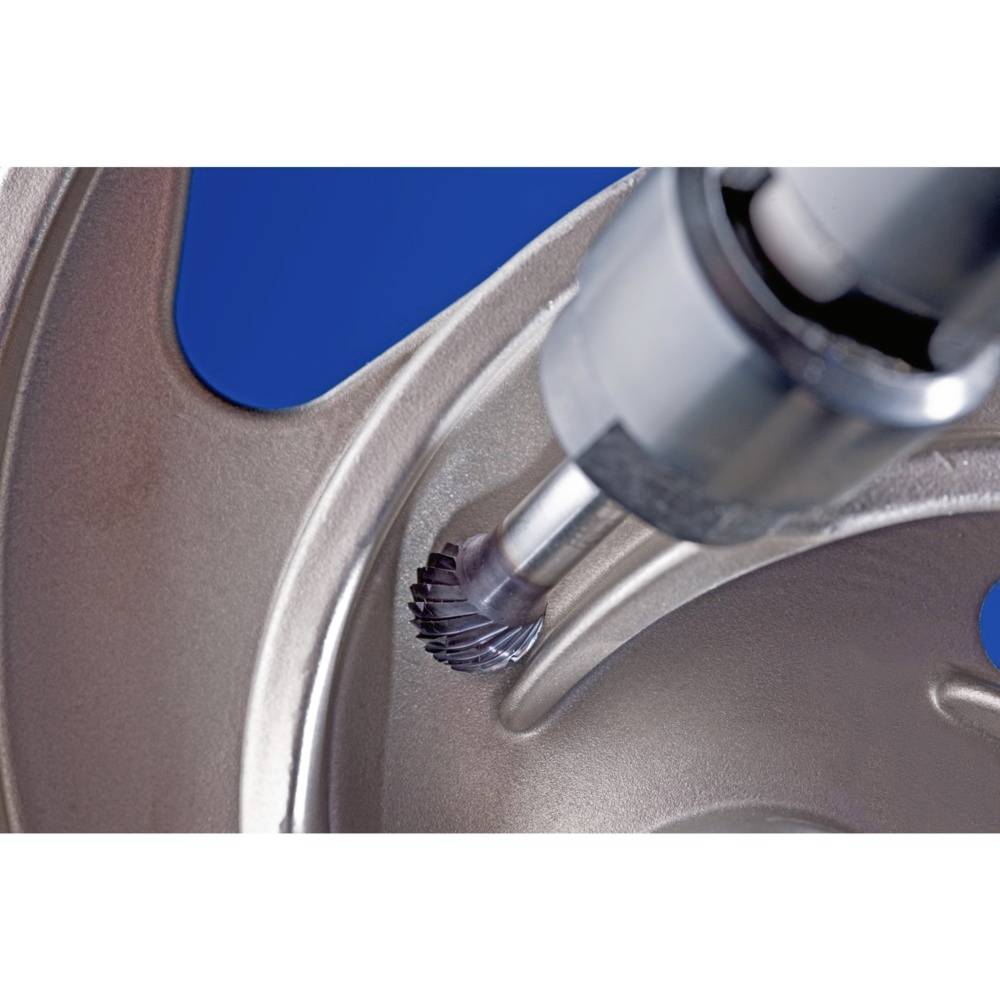 Nahaufnahme eines Metallwerkzeugs, das eine glatte Aussparung in einer metallischen Oberfläche formt; technische Präzision sichtbar.