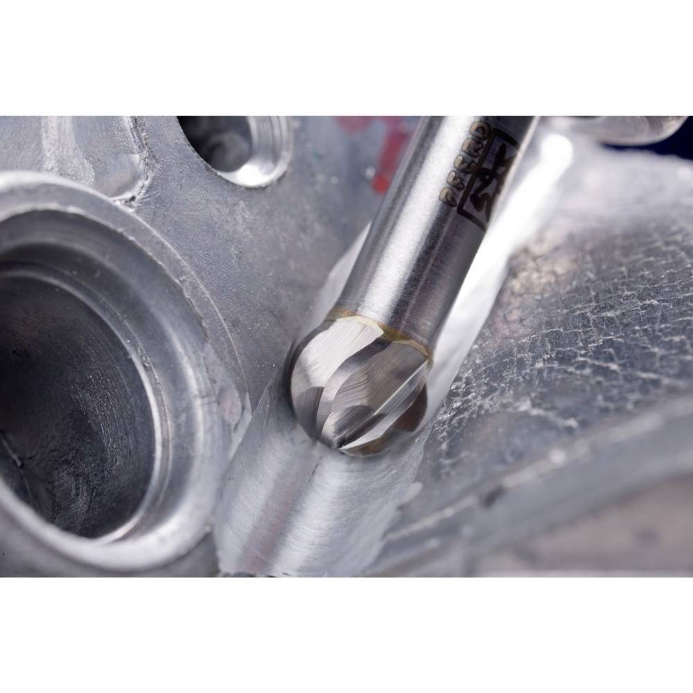 Nahaufnahme eines Bohrers, der ein Loch in ein Metallteil bohrt. Das Bild zeigt präzises Werkzeug und glatte Metalloberflächen.