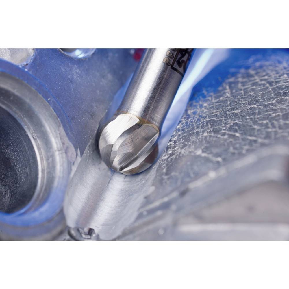 Nahaufnahme eines Bohrwerkzeugs, das Metall durchschneidet. Deutliche Metallspäne um die Schnittstelle, arbeitend an einer Maschinenkomponente.