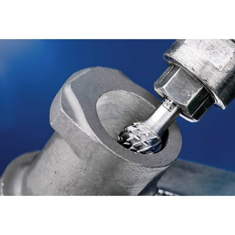 Nahaufnahme eines Metallbearbeitungsprozesses: Ein Rotationswerkzeug formt eine Metalloberfläche, um eine glatte Kante zu erzeugen.