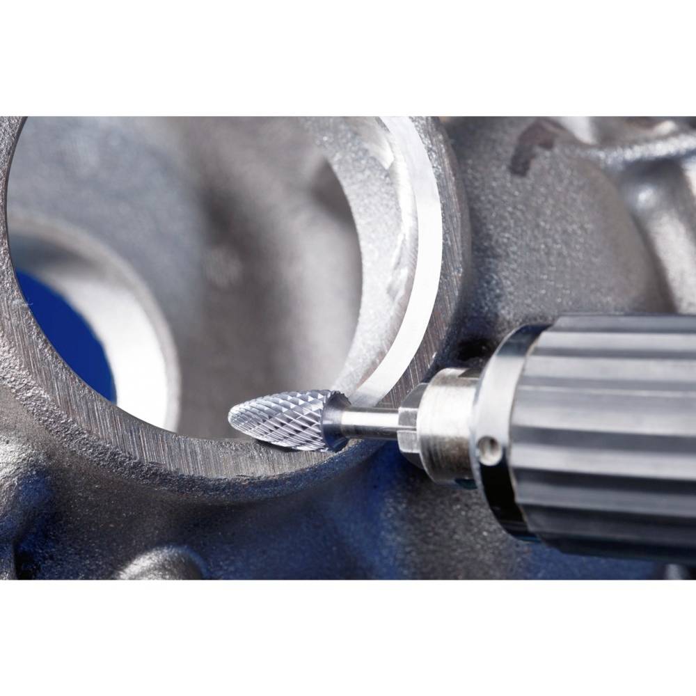 Nahaufnahme eines rotierenden Fräswerkzeugs, das Metall schleift. Das Metallstück hat eine geschliffene, abgerundete Kante.