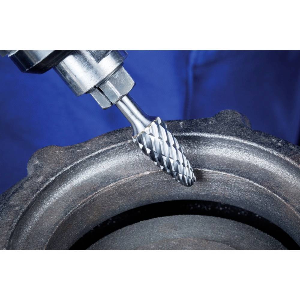 Eine Fräse bearbeitet die Oberfläche eines Metallzylinders. Die Bewegung der Fräse erzeugt feine Metallspäne.