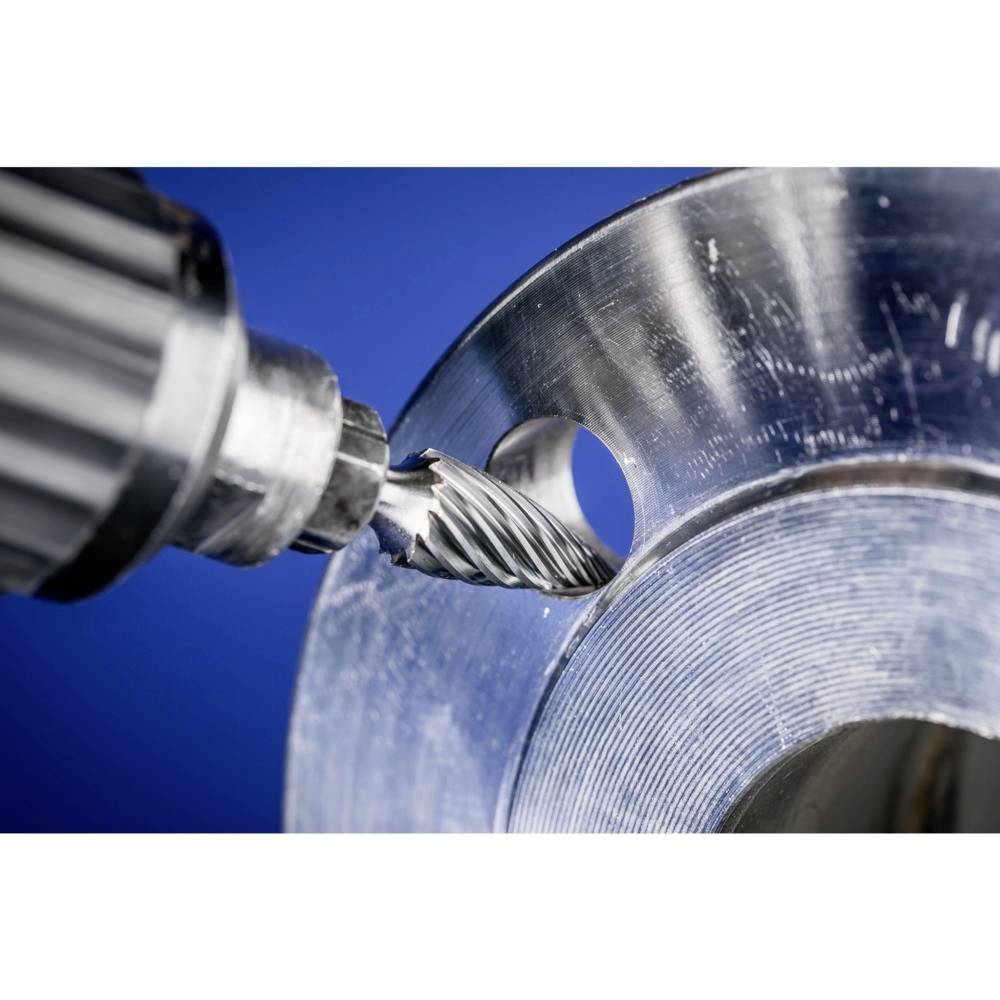 Eine Nahaufnahme eines Fräsers, der Metall bearbeitet. Der Fräser schneidet präzise kreisförmige Strukturen in die Metalloberfläche.