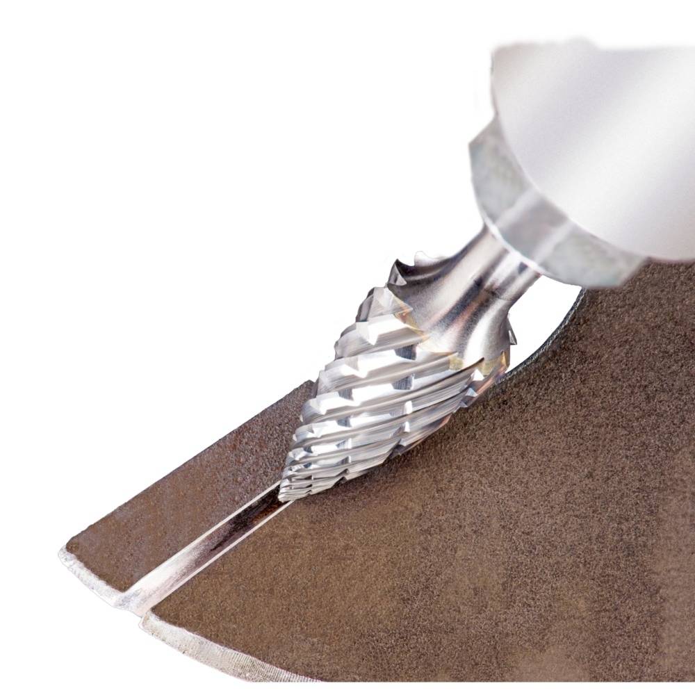 Nahaufnahme eines kegelförmigen Bohrers, der in Metall gebohrt wird. Deutlich sind die Spiralrillen und die Metallspäne zu sehen.