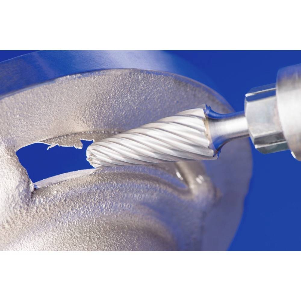 Nahaufnahme eines Fräswerkzeugs, das Metall bearbeitet. Das Werkzeug schneidet in eine silberne Metalloberfläche gegen einen blauen Hintergrund.