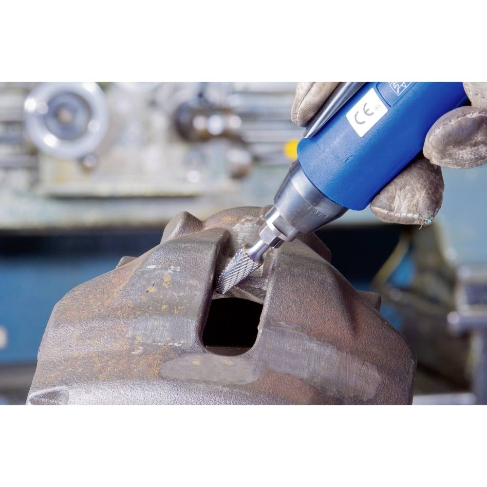 Nahaufnahme eines Arbeiters, der mit einem blauen Werkzeug eine Metalloberfläche schleift. Die Szene zeigt industrielle Tätigkeit.