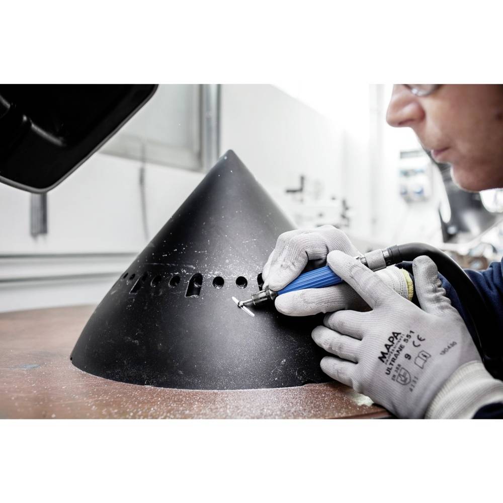 Eine Person arbeitet mit einem Werkzeug an einem großen, schwarzen Metallkegel, möglicherweise zur Feinbearbeitung oder Reparatur.