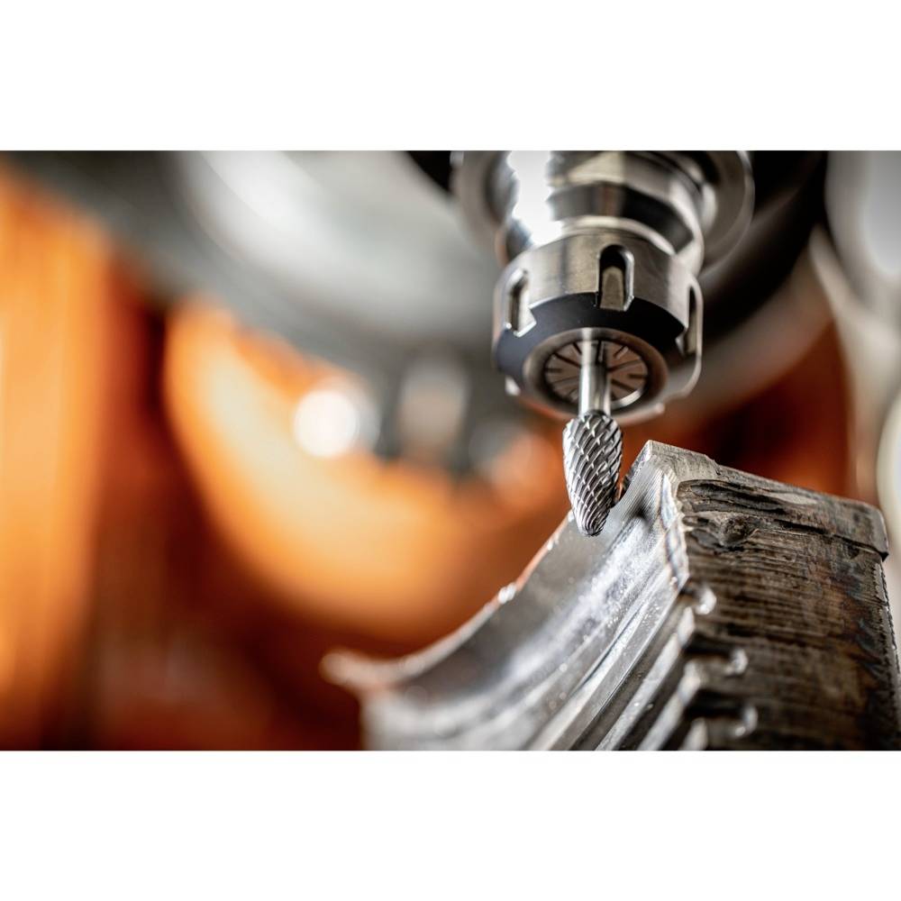 Ein Industrieschneider bearbeitet eine Metalloberfläche, Funken fliegen. Die Szene zeigt präzise Metallverarbeitung in Nahaufnahme.