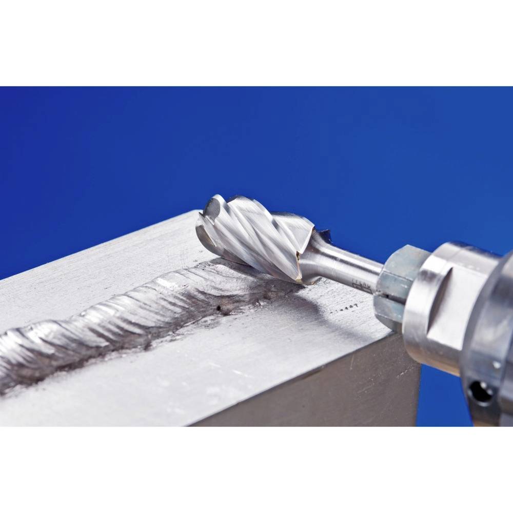 Bohrer entfernt eine Schweißnaht von einer Metalloberfläche. Der Bohrer ist in einem rotierenden Werkzeug eingespannt.