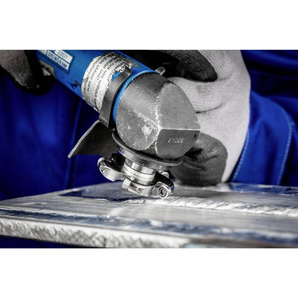 Person mit grauem Handschuh benutzt einen blauen Winkelschleifer, um Metalloberfläche zu bearbeiten. Nahe Aufnahme.