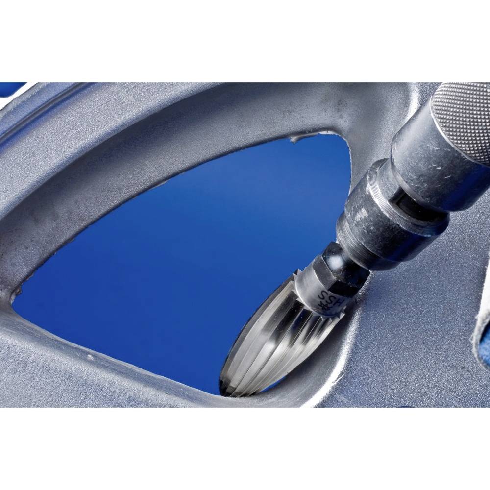 Nahaufnahme eines Bohrers, der eine dünne Metallplatte durchbohrt. Der Hintergrund ist blau.