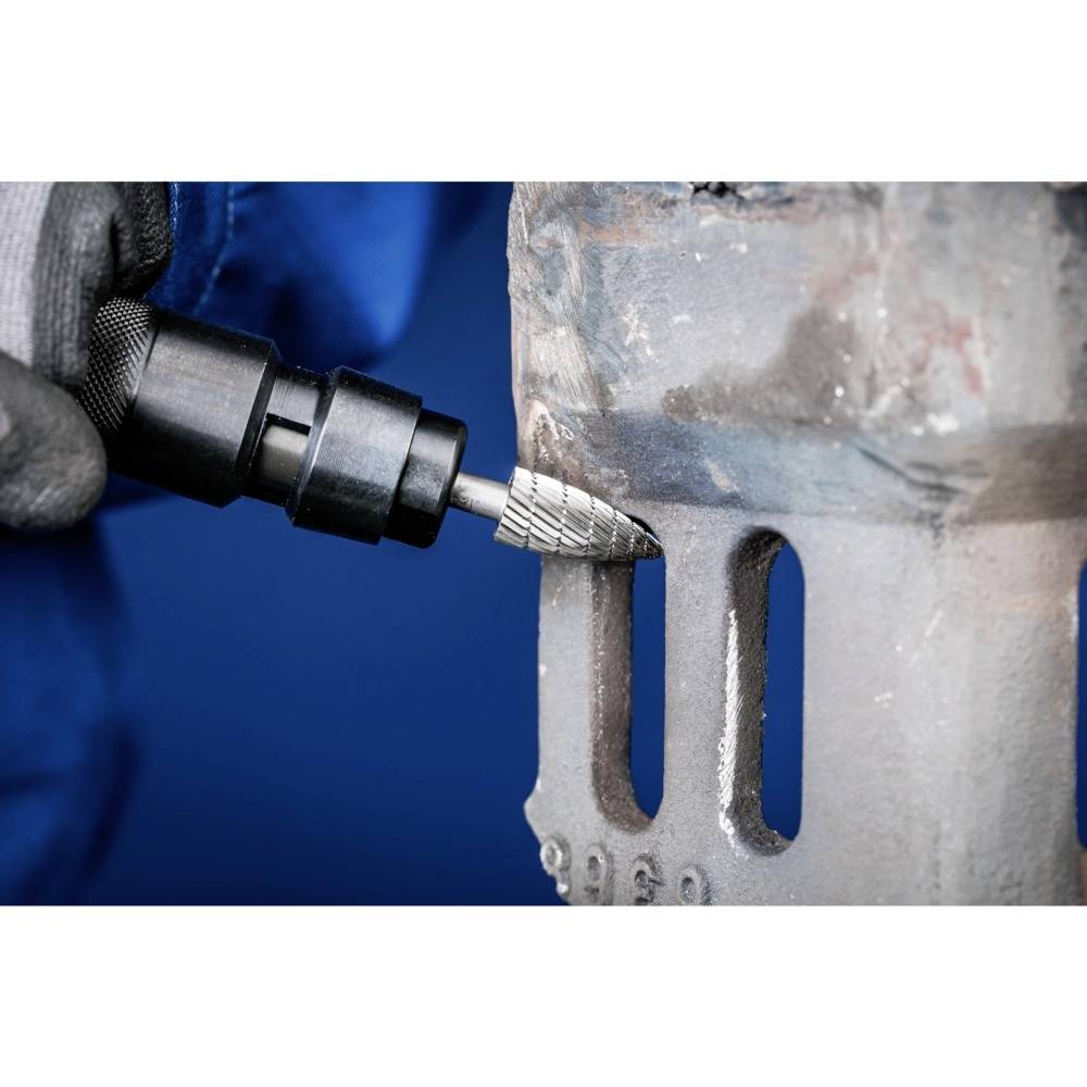 Eine Person in Arbeitskleidung entfernt mit einem Schleifwerkzeug Rost von einer Metalloberfläche. Der Hintergrund ist blau.