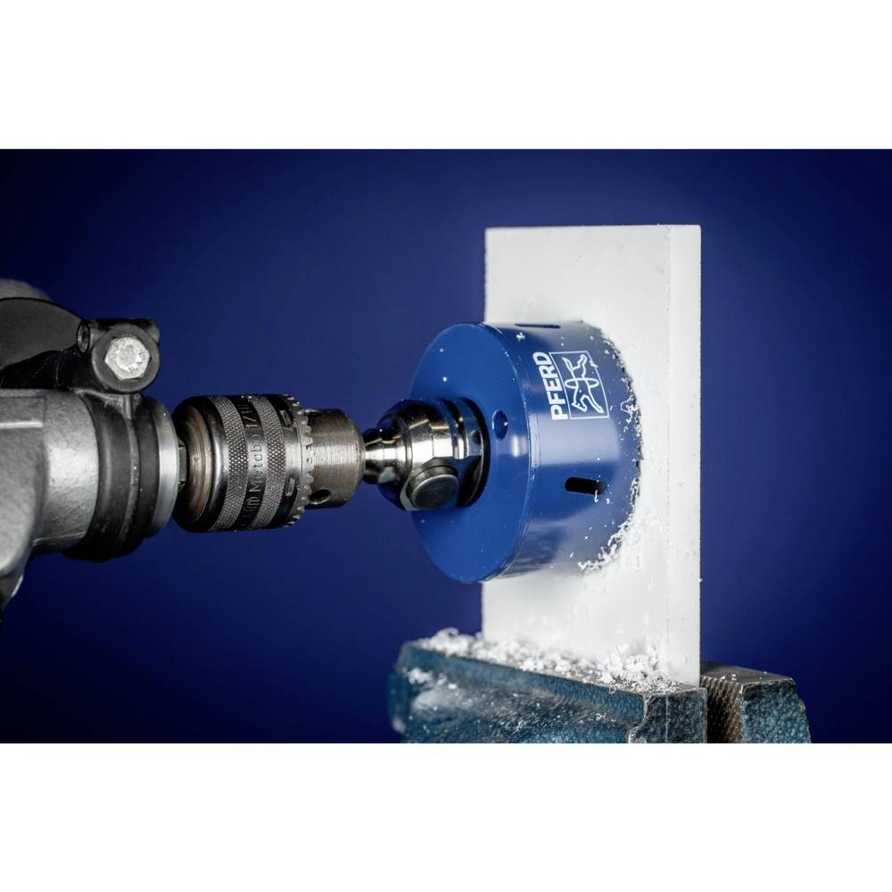 Nahaufnahme einer Bohrmaschine, die mit einem blauen Bohraufsatz ein Loch in eine weiße Platte bohrt. Späne sind zu sehen.