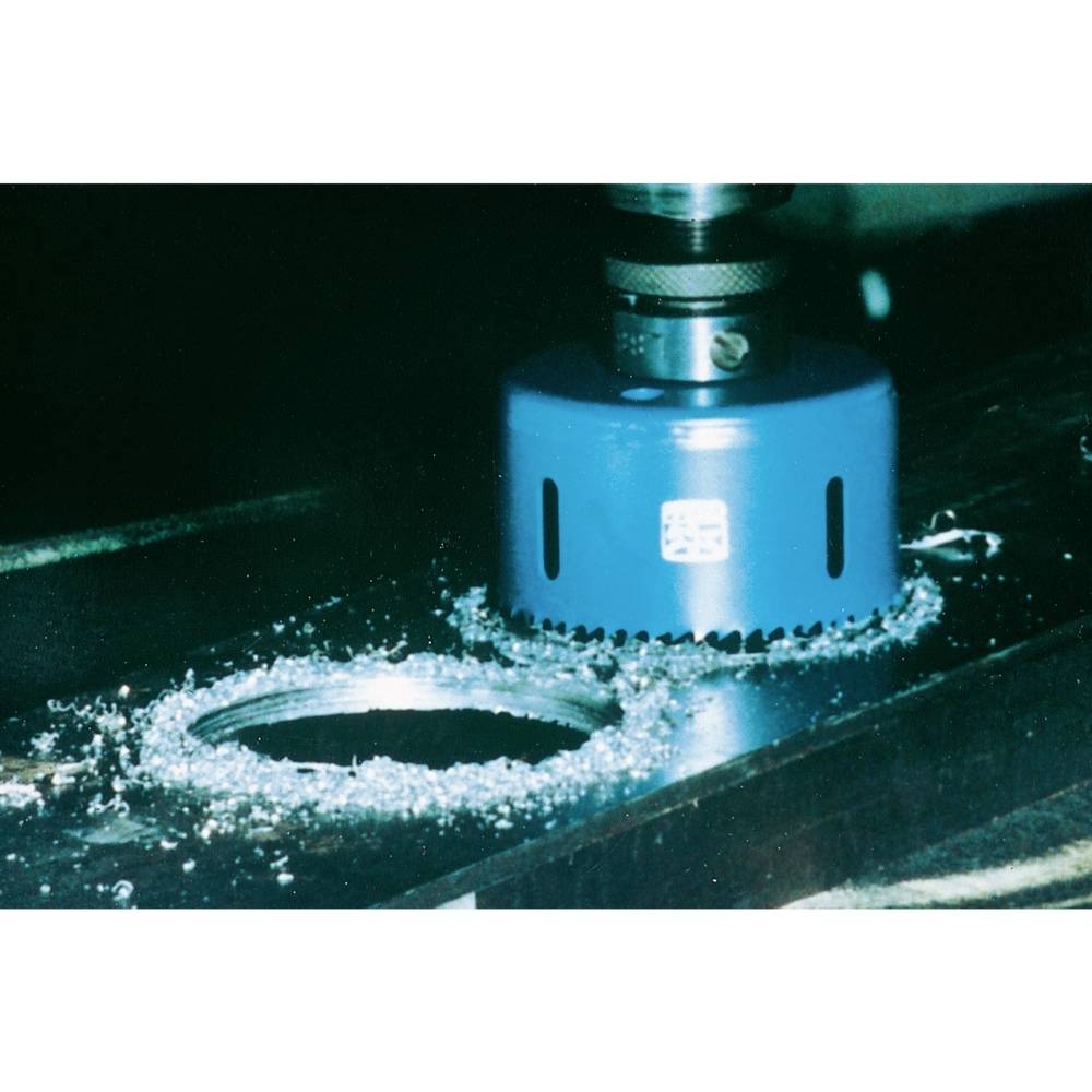 Das Bild zeigt eine blaue Lochsäge, die ein rundes Loch in ein Metallstück schneidet, umgeben von Metallspänen.