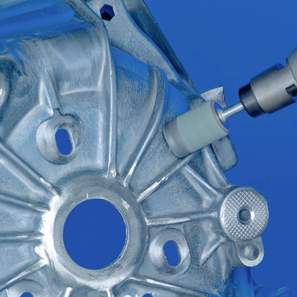 Eine Maschine poliert eine runde Metalloberfläche mit mehreren Bohrungen, wahrscheinlich Teil einer Fahrzeug- oder Maschinenkomponente.