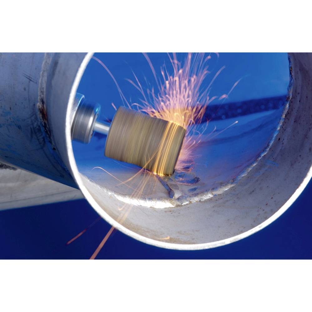 Ein Metallrohr wird mit einem rotierenden Schleifwerkzeug bearbeitet, Funken fliegen auf blauem Hintergrund.