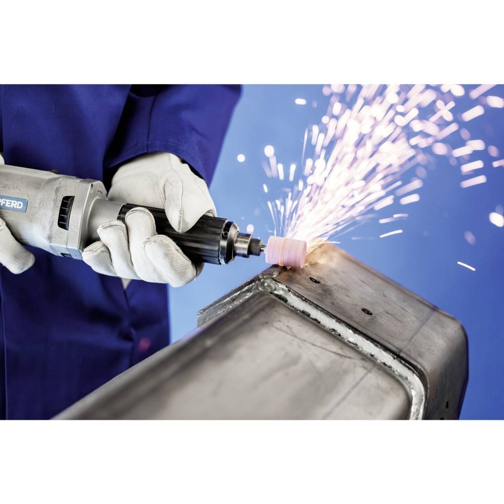 Eine Person in Schutzkleidung schleift Metall mit einem Winkelschleifer, wobei Funken sprühen. Hintergrund ist blau.