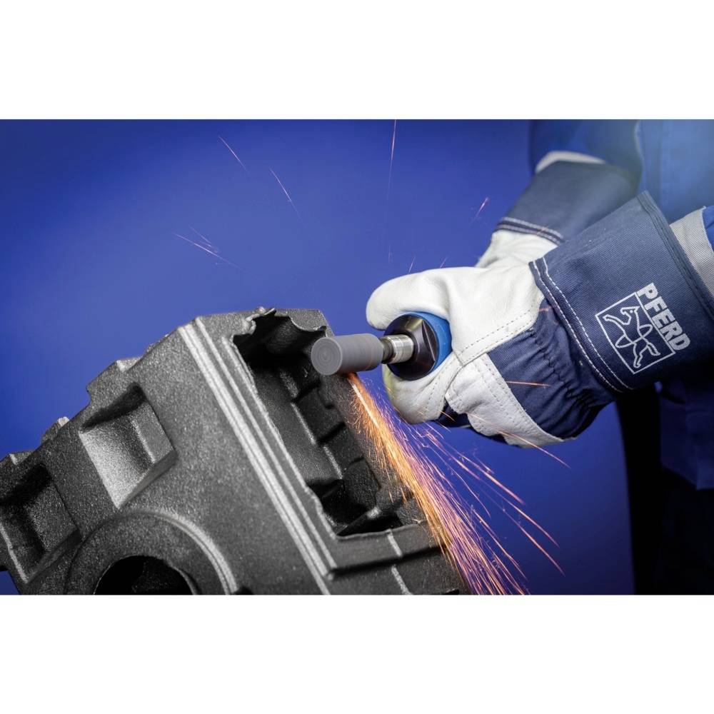 Eine Person trägt Schutzhandschuhe und schleift mit einem elektrischen Werkzeug Funken an einem metallischen Werkstück ab.