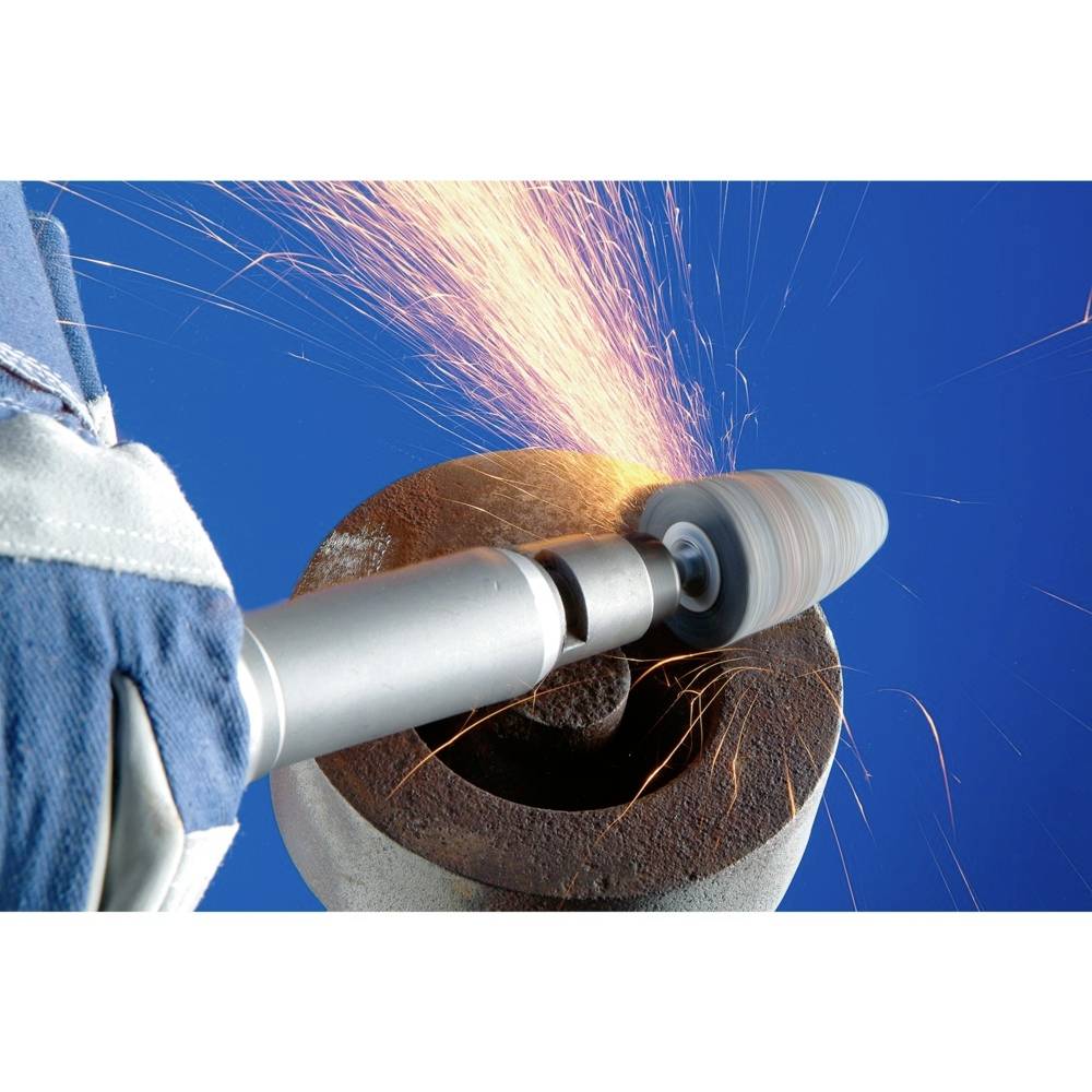 Eine gloved Hand hält ein Schleifwerkzeug, das Funken verursacht, während es auf einem Metallstück arbeitet, vor blauem Hintergrund.