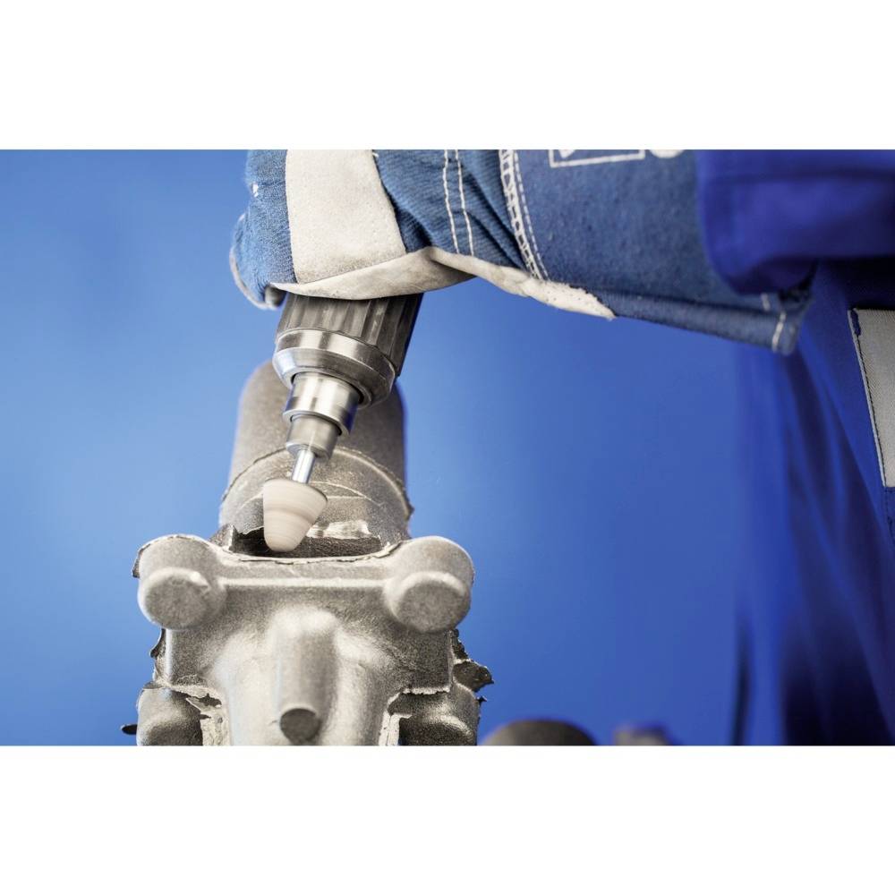 Eine Person arbeitet mit einem Schleifwerkzeug an einem Metallteil. Der Fokus liegt auf Präzision und Detailbearbeitung der Oberfläche.