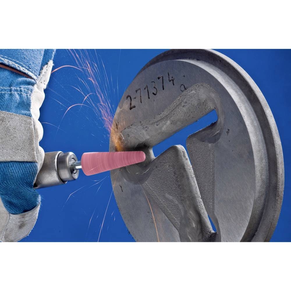 Eine Person schleift ein rundes Metallteil mit einem rotierenden Schleifwerkzeug. Funken fliegen, während der Schleifprozess fortschreitet.