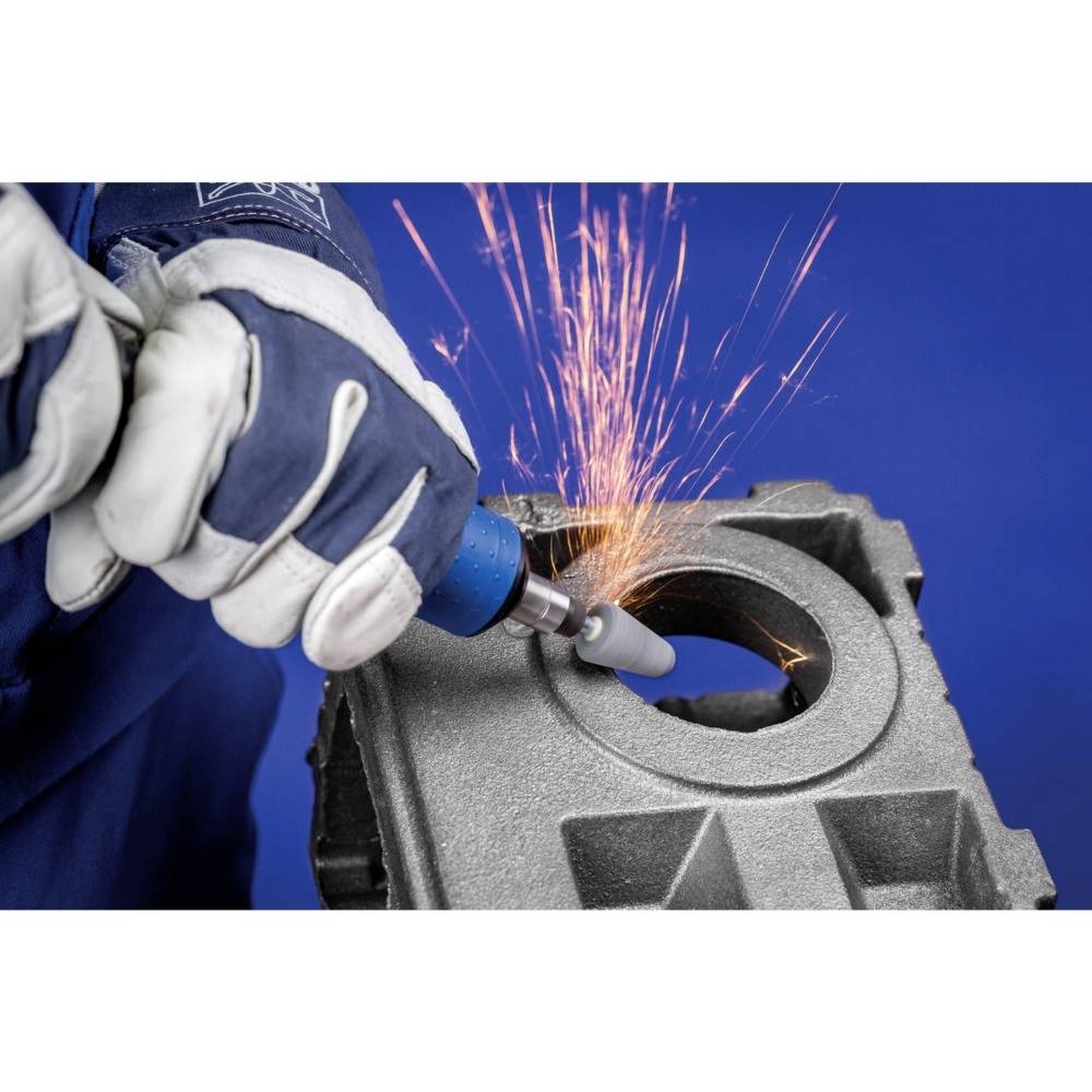 Eine Person schleift Metall mit einem Werkzeug, Funken fliegen. Die Person trägt Schutzhandschuhe.