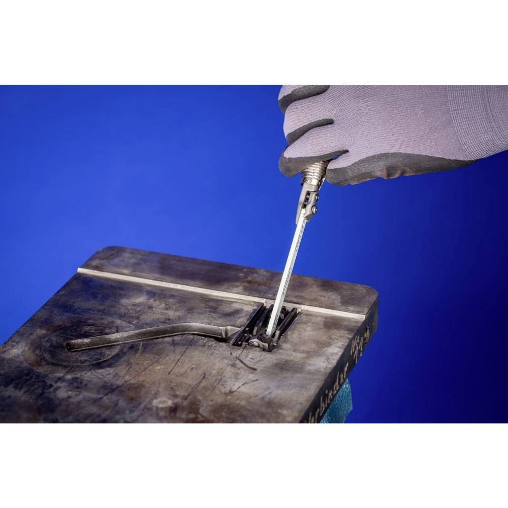 Eine Person mit Handschuhen benutzt einen Schraubendreher, um einen abgenutzten Schraubenkopf in einem Metallblock zu drehen. Hintergrund ist blau.