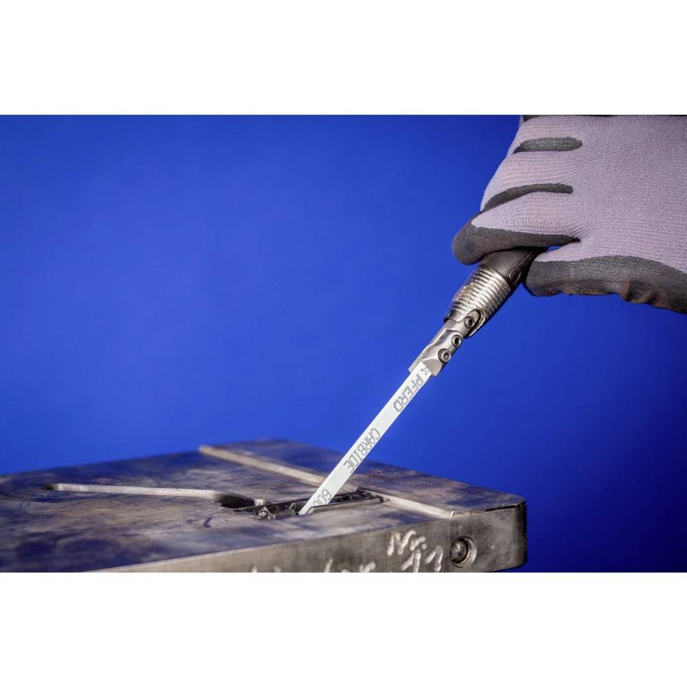 Eine Hand mit grauem Handschuh hält einen silbernen Gravurstift, der auf eine Metallplatte zeigt. Hintergrund ist blau.