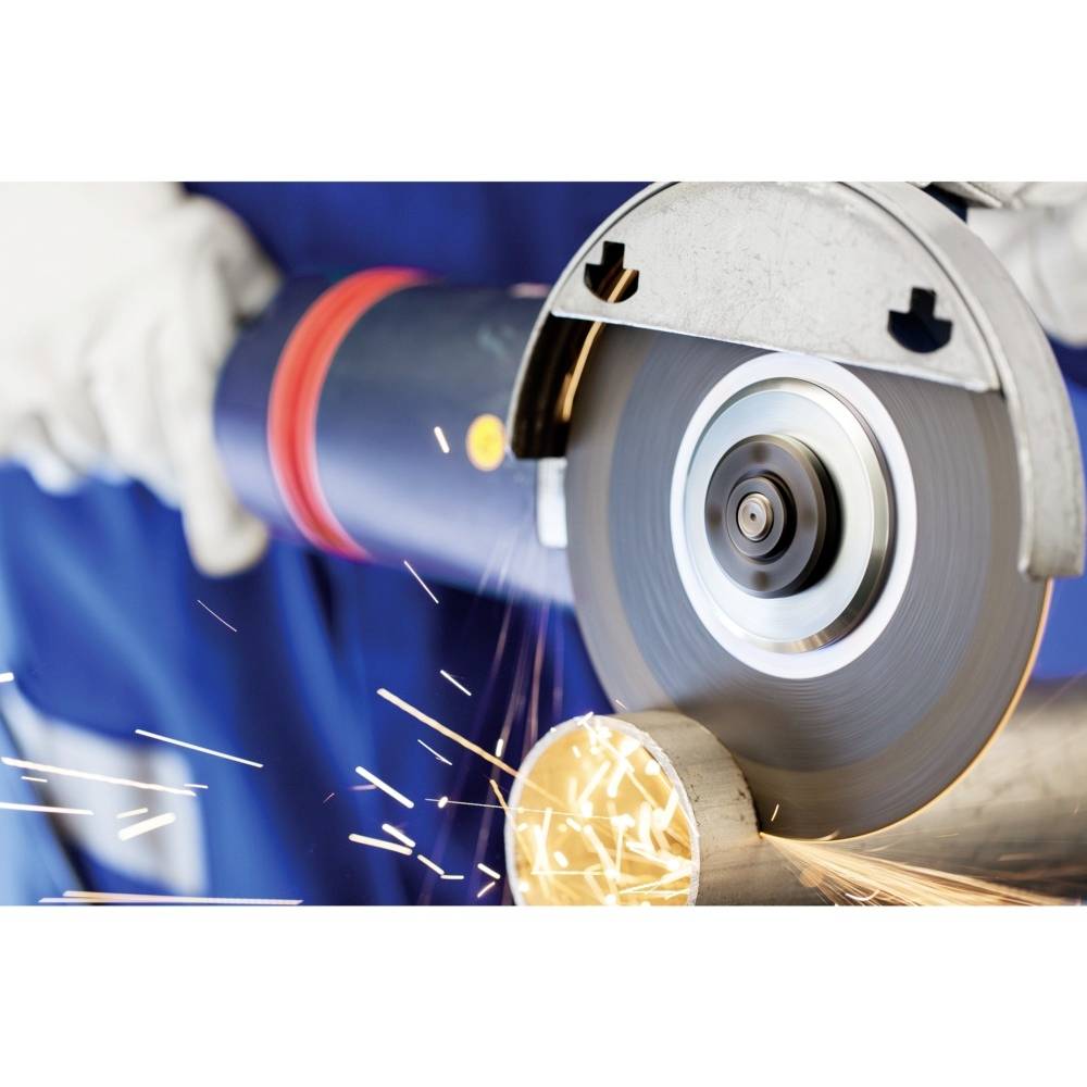 Eine Person schneidet mit einem Winkelschleifer Metallrohre. Funken sprühen, während das Gerät präzise geführt wird.