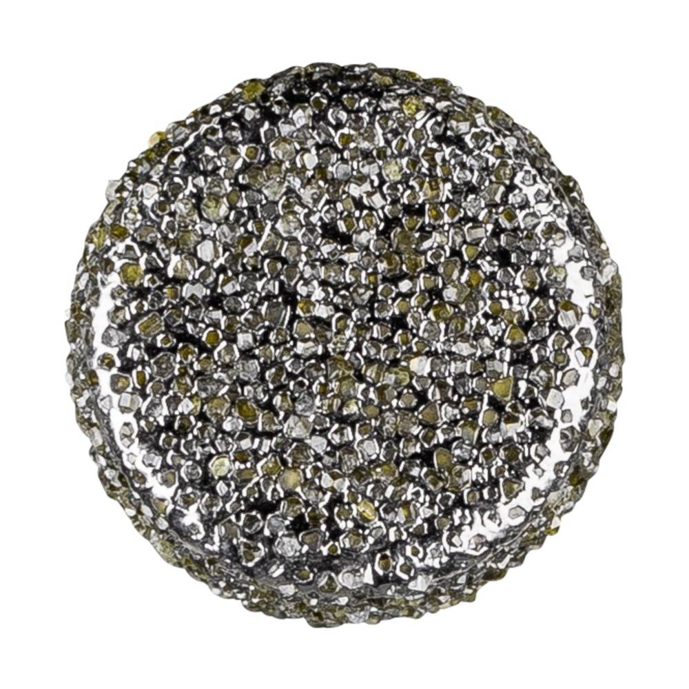 Runder Knopf mit rauer, glitzernder Oberfläche aus kleinen, goldfarbenen und silbernen Steinen.
