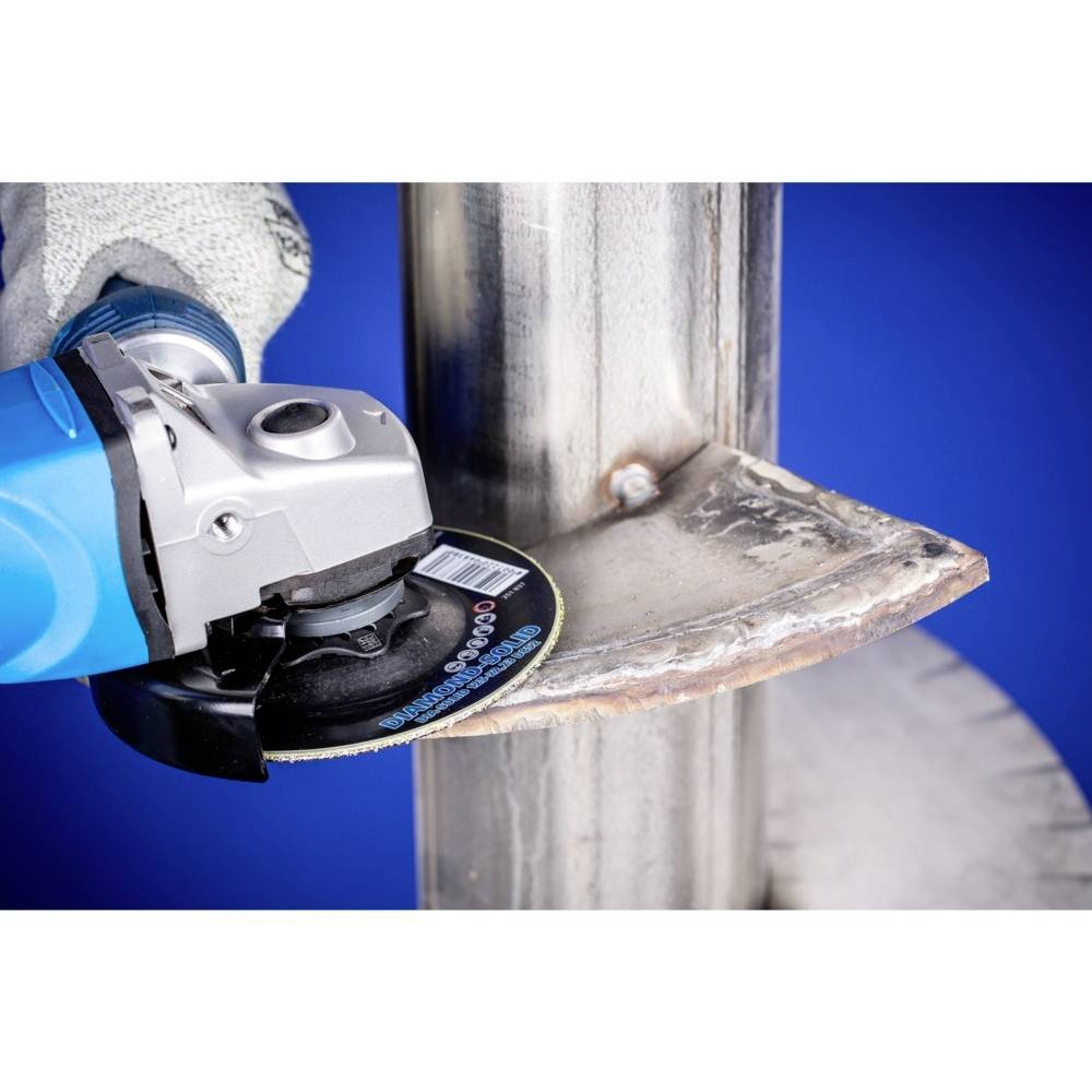 Eine Person schleift mit einem Winkelschleifer ein Metallrohr. Funken fliegen, während der abrasive Schnitt erfolgt.