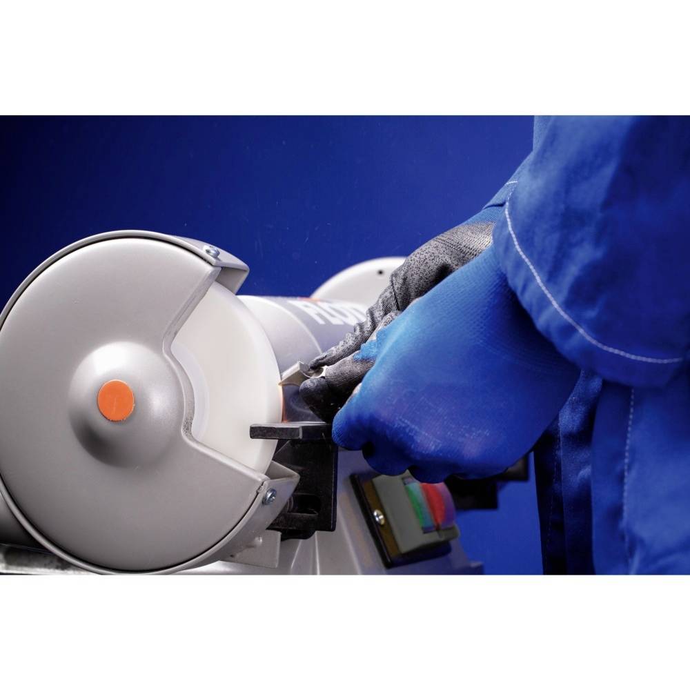 Eine Person in blauen Handschuhen schleift mit einer Schleifmaschine Metall. Das Bild zeigt Nahaufnahme der Arbeitshandlung.